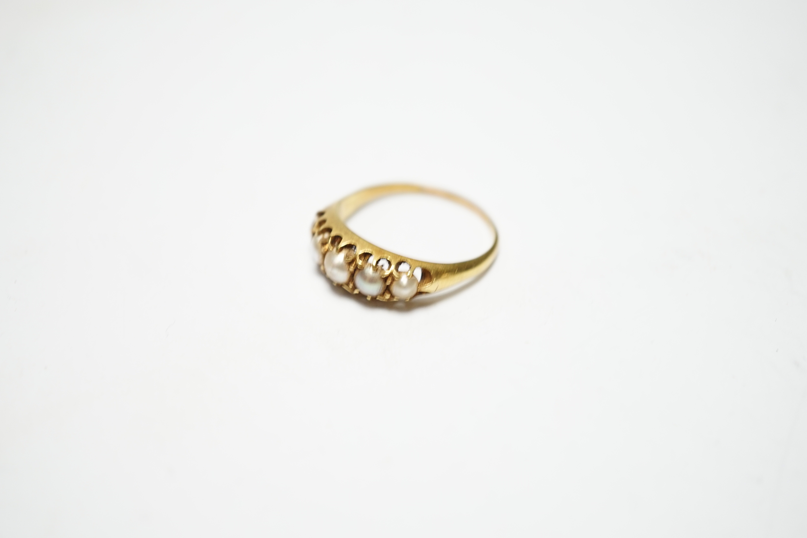 A Victorian yellow metal and graduated split pearl set half hoop ring, size S, gross weight 4 grams.